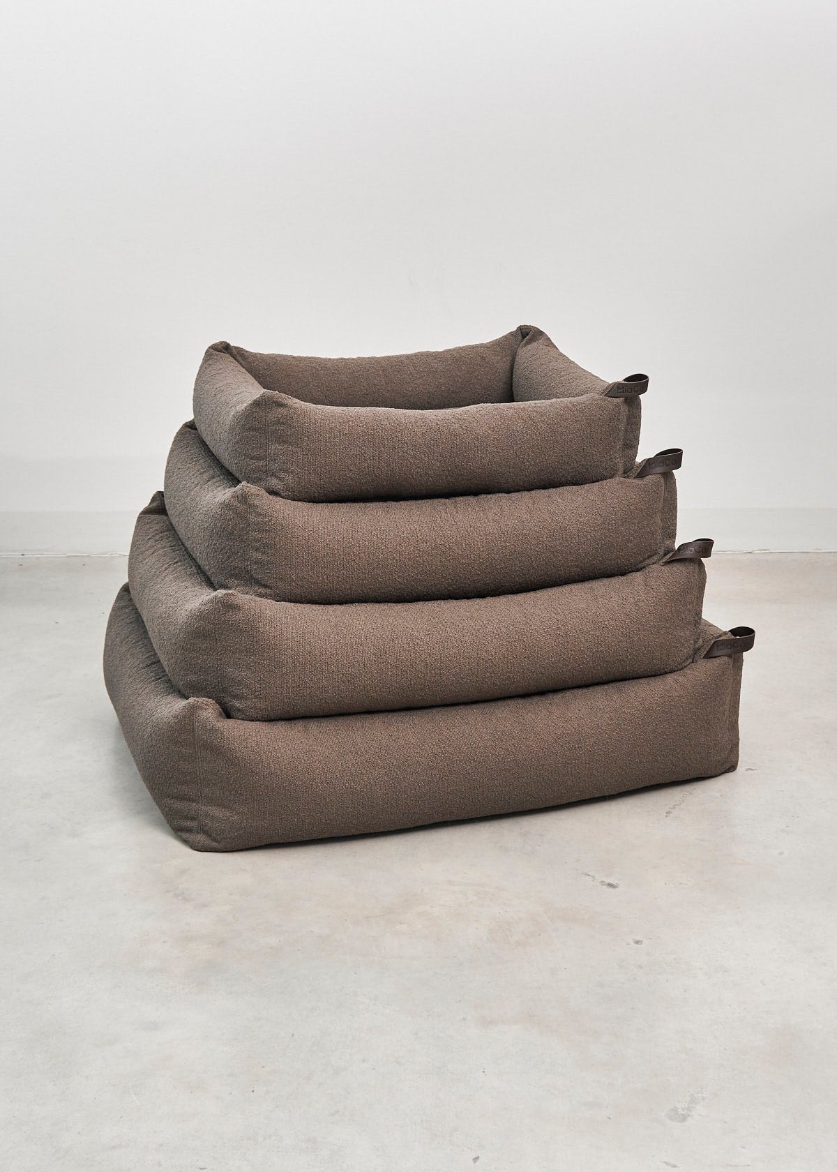 Modern hondenbed met bouclé stof, orthopedisch matras en afritsbare hoes.